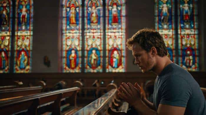 Christ pratt praying in a church